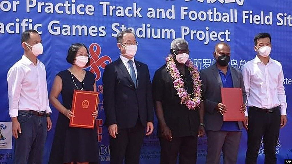 资料照片：所罗门群岛总理索加瓦雷（右三）与中国驻所罗门群岛大使李明（左三）与其他官员在霍尼亚拉中国援建的体育馆项目开工仪式上合影。（法新社2022年4月22日照片）