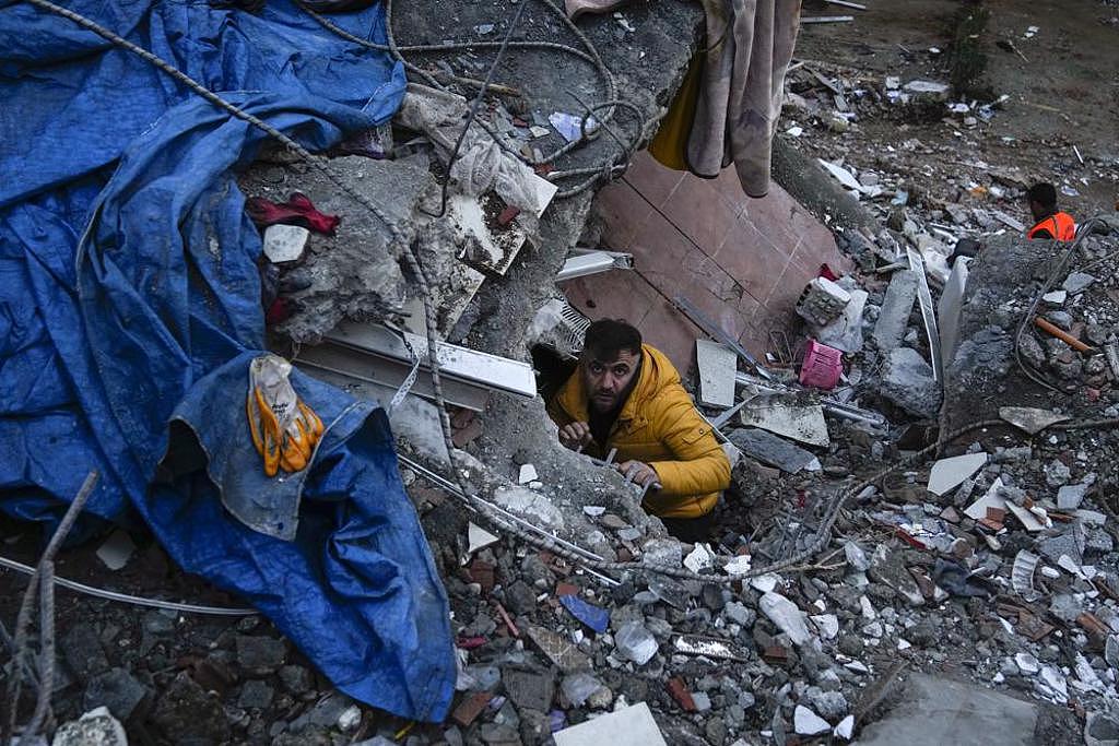 土耳其救援人員幾乎徒手的方式，在瓦礫堆裡尋找悻存者。(圖/美聯社)