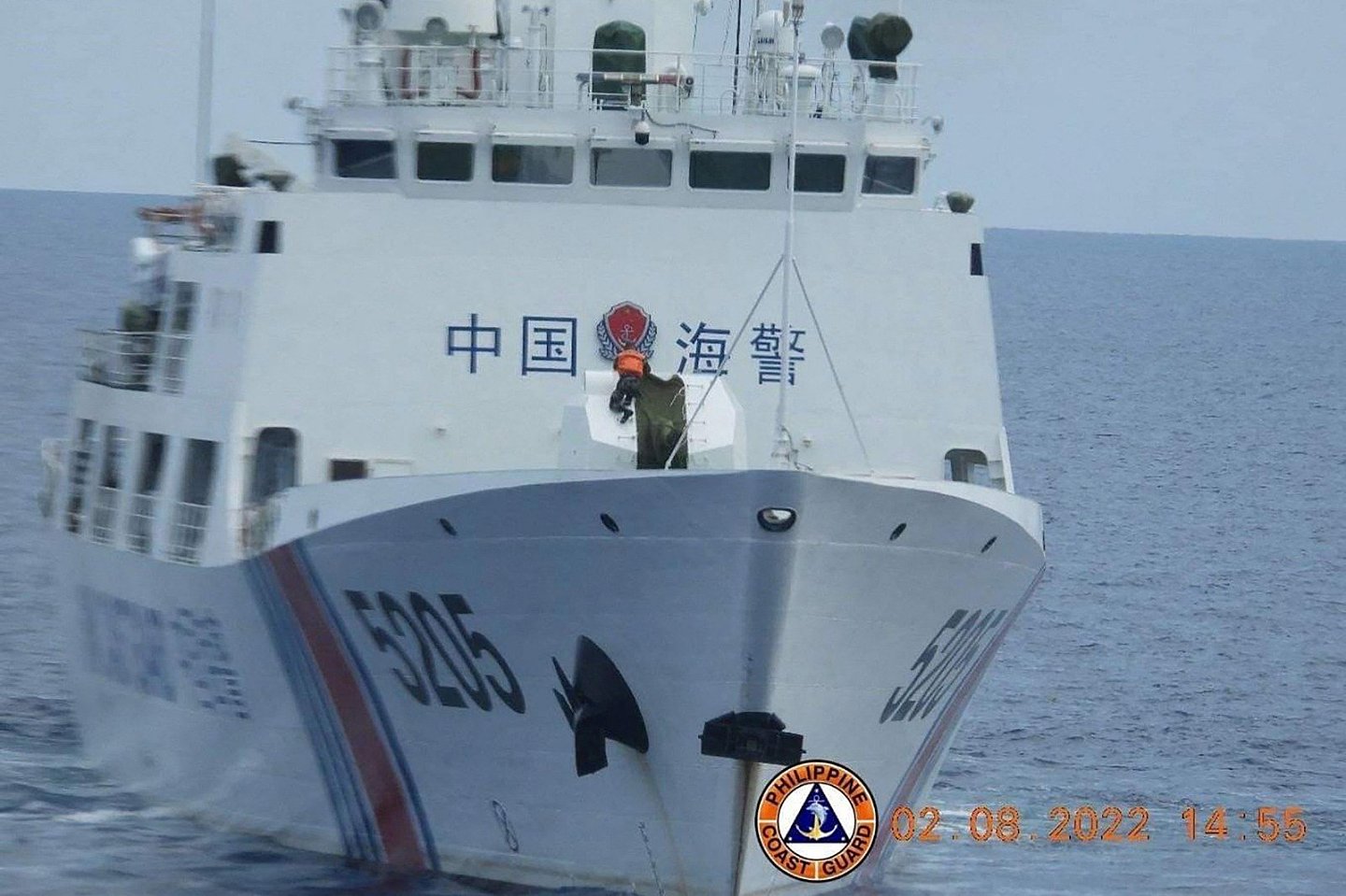 菲律宾海岸警卫队在周一发布这张去年8月8日拍摄的照片，位于有争议的南中国海南沙群岛的仁爱礁附近水域，中国海岸警卫队船只上的一名水手（身穿橙色背心）正在拆除其“70毫米海军武器”的外壳。（图取自菲律宾海岸警卫队/法新社）