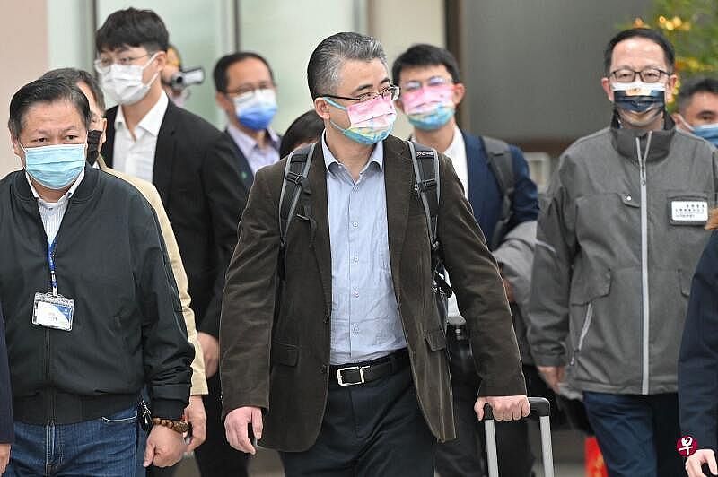 上海台办副主任李骁东（左二）上午抵达台湾松山机场。（法新社）