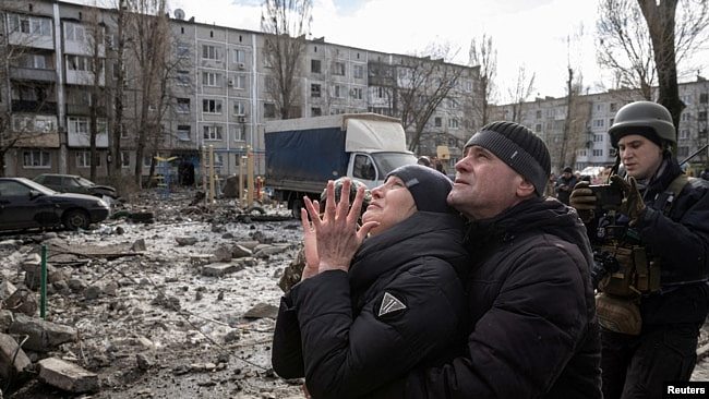 2023年2月15日，在乌克兰顿涅茨克州，民众站在一栋被导弹击中严重受损的公寓楼前。（路透社照片）