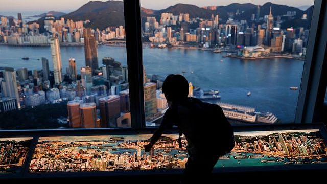 香港九龙一处摩天大楼观景台上一名小孩靠窗玩耍