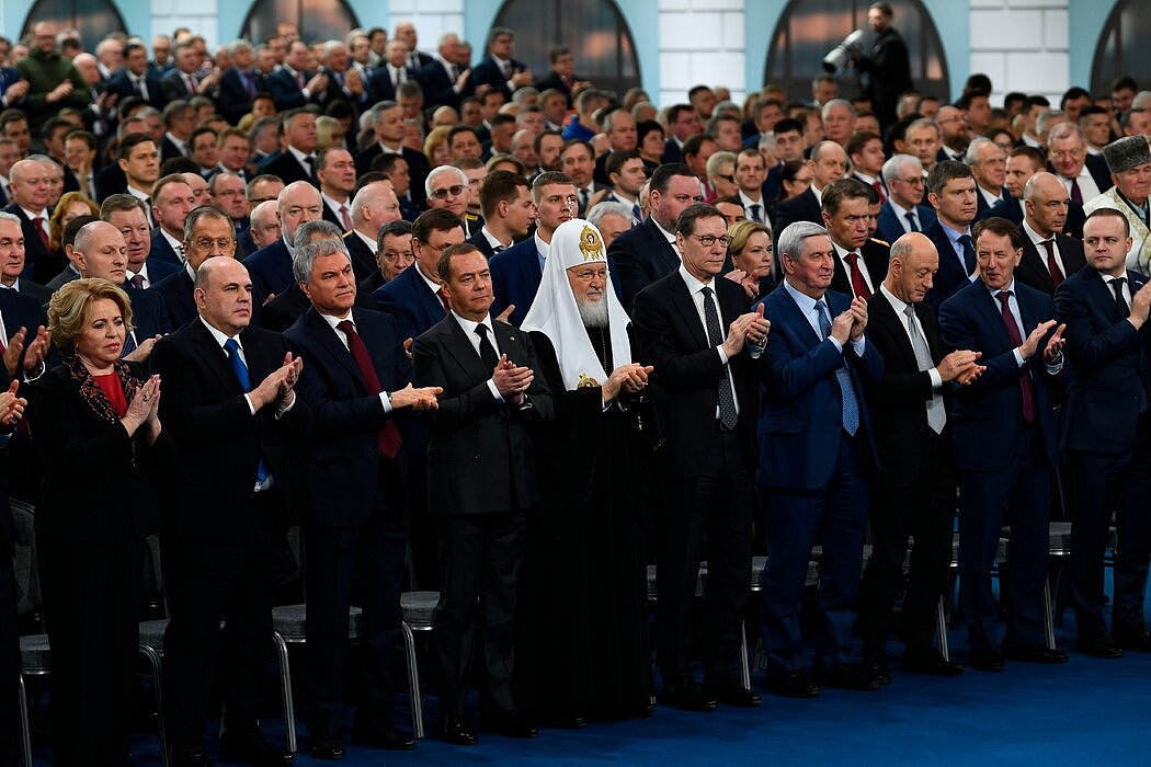 俄罗斯官方媒体发布的一张照片显示，官员和议员周二在为普京鼓掌，其中包括俄罗斯东正教大牧首基里尔（中），以及站在他右侧的梅德韦杰夫。