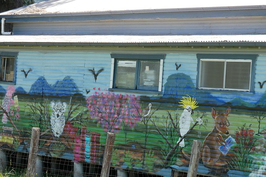 Mural of colourful birds and animals on the wall of a building.