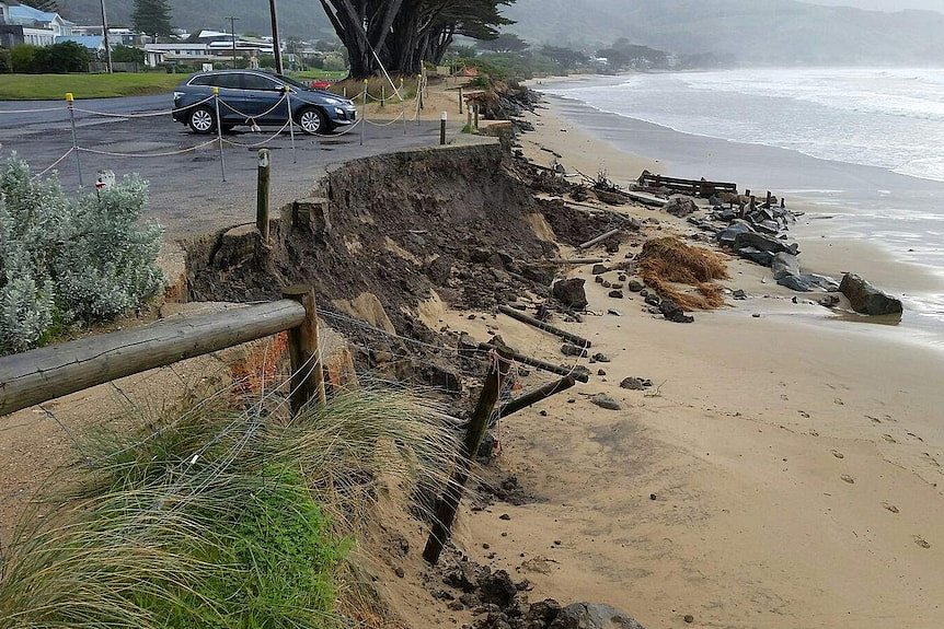 The edge of a carpark that has collapsed onto a beach.