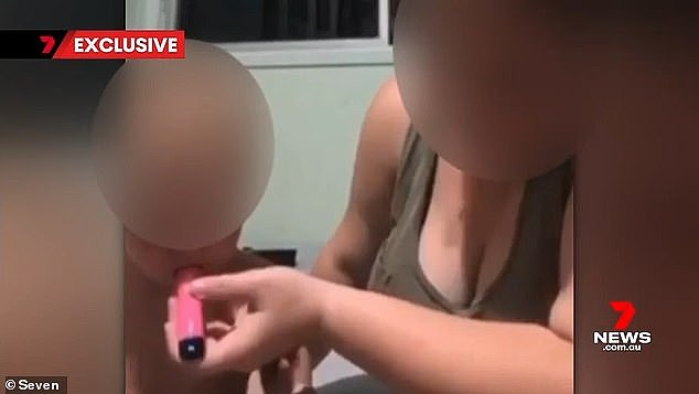 A 16-year-old Queenslander has been exposed for a video showing her forcing a reportedly nicotine vape to her one-year-old sister (pictured)