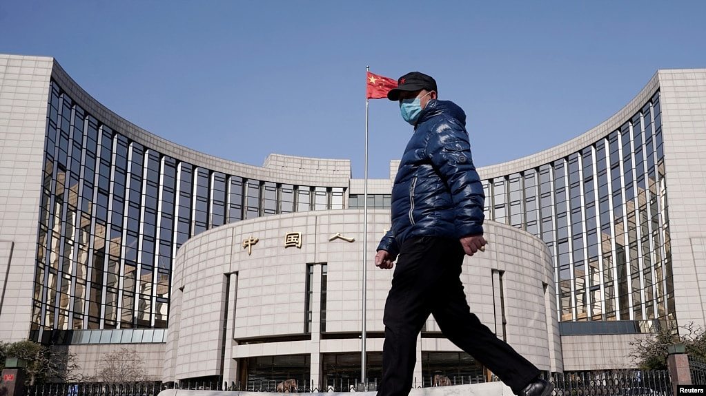 一名戴着口罩的男子走过北京的中国人民银行总部。（2020年2月3日）