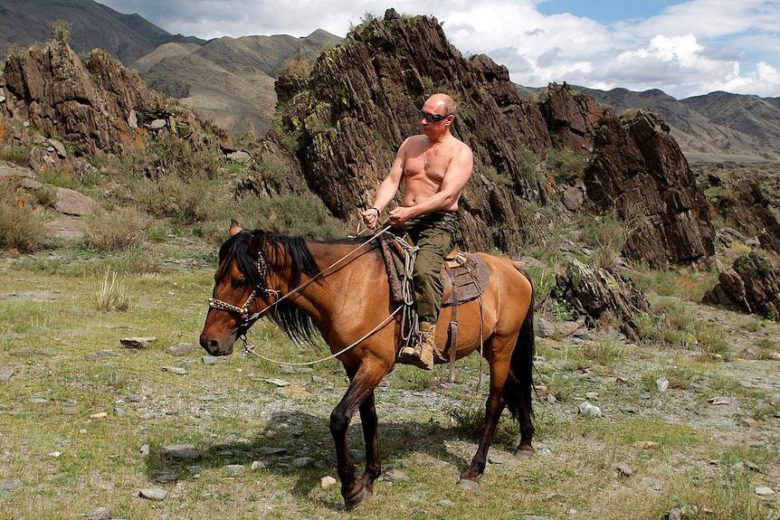 Vladimir Putin shirtless on horseback in Siberian mountains.