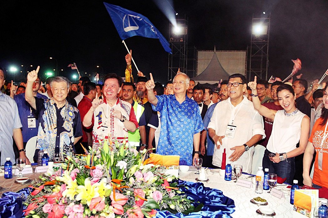 图为2013年，杨紫琼与马来西亚前首相纳吉（中间身着蓝衣者）的合照。 图／纳吉脸...