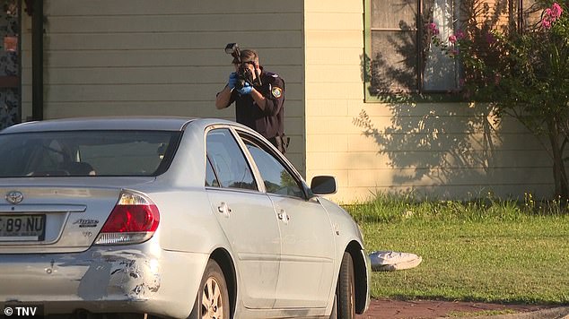 Police take pictures of the crime scene on Bradshaw Avenue in Sydney's west