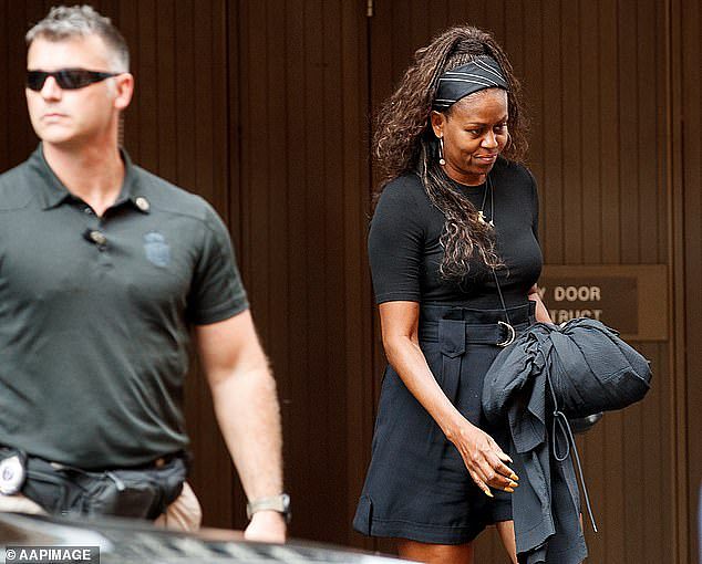 Former US first lady Michelle Obama leaves the Four Seasons Hotel in Sydney on Tuesday, March 28, 2023. The Obamas are protected by US Secret Service officers, such as the man pictured to her left