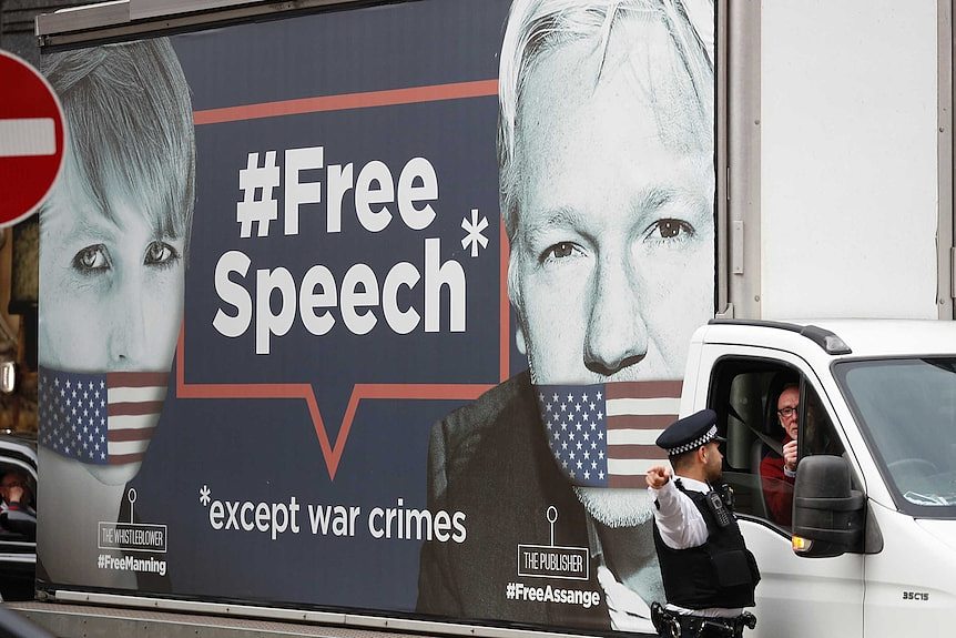 A man drives a truck with the images of Wikileaks founder Julian Assange and whistleblower Chelsea Manning on its side.