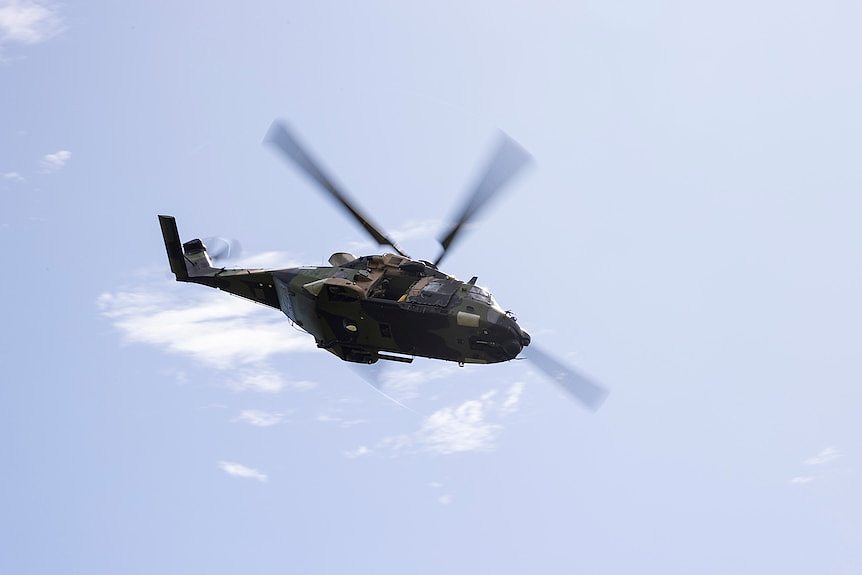 An Australian Army MRH90 helicopter in flight during a clear day.