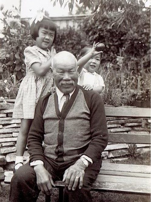 Black and white family photo, older man with two kids behind