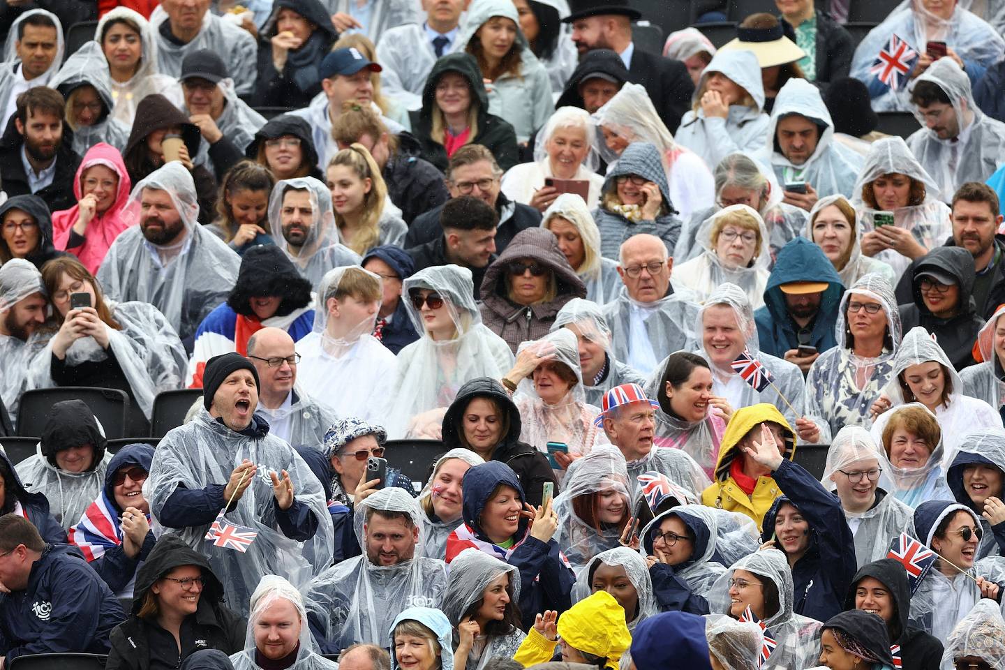 查里斯加冕：图为2023年5月6日，民众披雨衣在伦敦等候观看加冕巡游。 （Reuters）