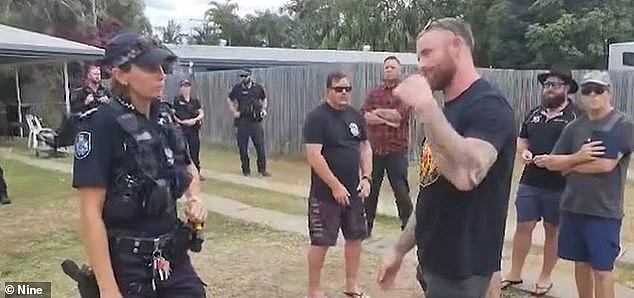 Torin O'Brien (right) is pictured in discussion with a police officer amid a tense stand-off over a 'crime wave' in Rockhampton