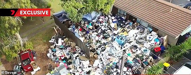 Neighbours said the enormous pile (pictured), which included fridges, tools, Christmas decorations, clothing and a massage chair, was crawling with rats and snakes