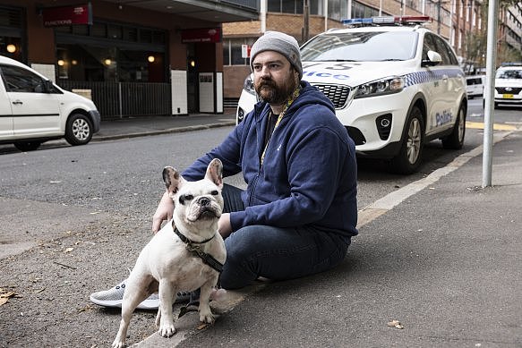 Jeff Masters 和他的狗 Remy 坐在一起，等待有人护送到他的公寓去取一些个人物品。