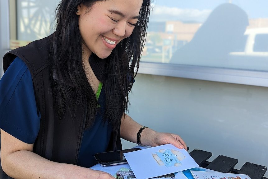 Amelia Yu smiles as she looks down at some thank you cards she received from her clients. 