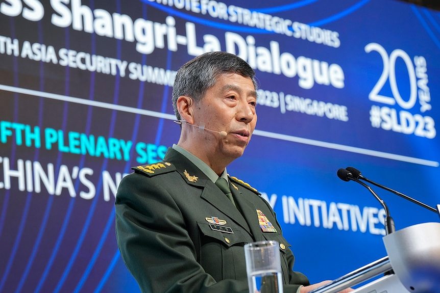 Li Shangfu  in uniform speaks at the lectern of a forum in Singapore