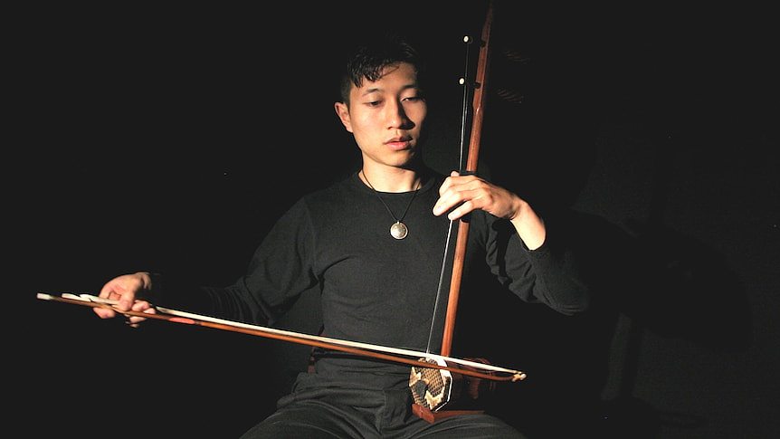 Nicholas Ng plays the Chinese bowed instrument, the Erhu. The snakeskin on the resonator box is clearly visible.. 