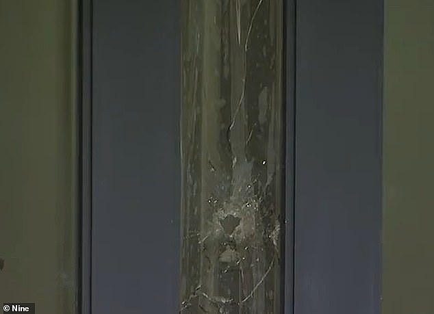Footage from the aftermath shows a bullet hole through the front door of the Donvale property (pictured)