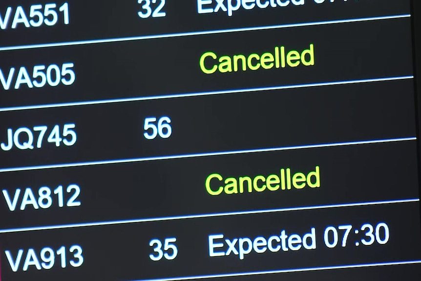 An airport sign displaying information about cancelled flights.