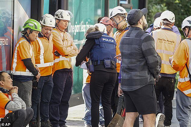 2023 年 7 月 20 日星期四，新西兰奥克兰发生大规模枪击事件后，警方在中央商务区采访建筑工人