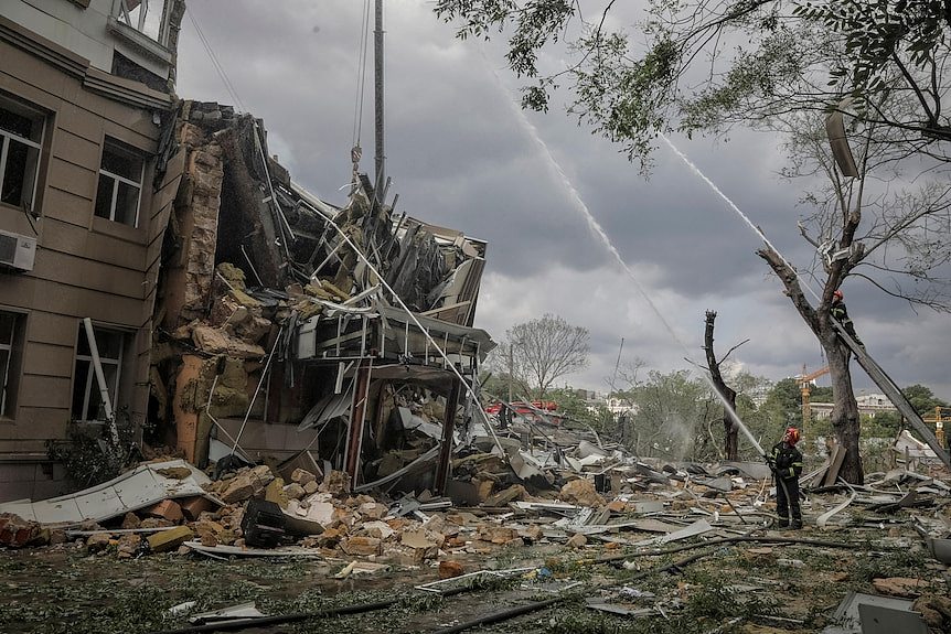 Rescuers work at a site of a building heavily damaged by a Russian missile attack.