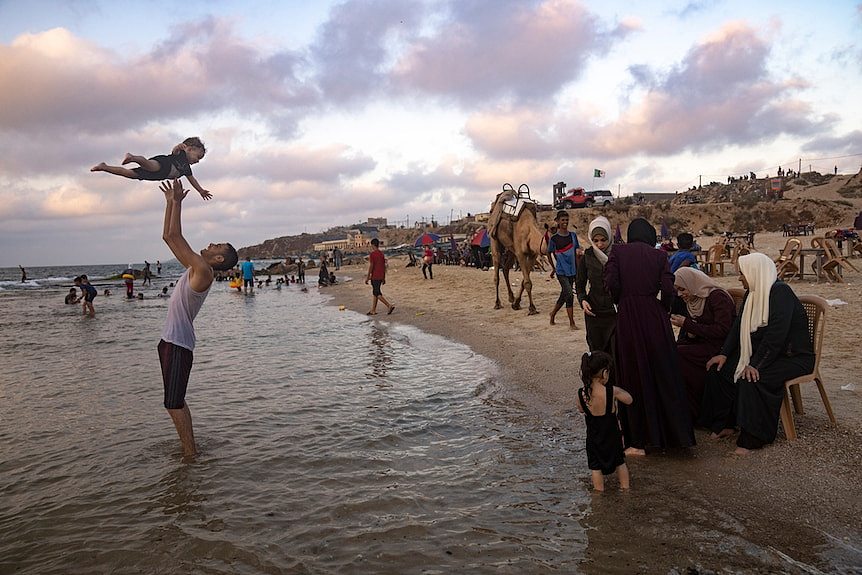 7月23日星期日，巴勒斯坦人在加沙城的热浪中享受地中海海滩上度过一天。