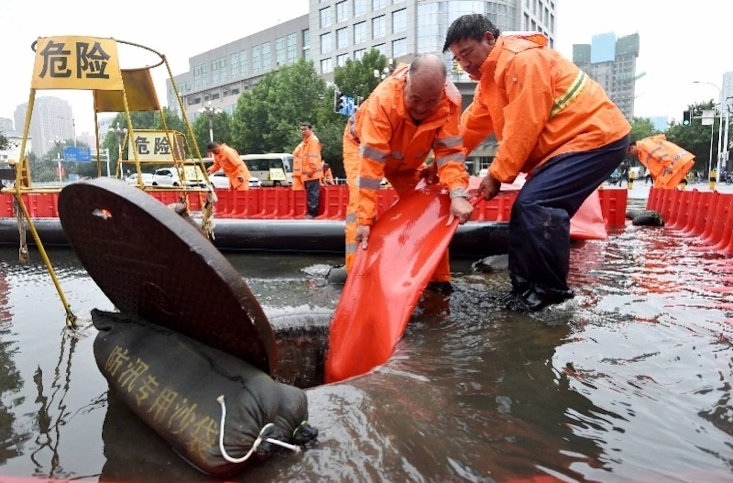 7月31日，在河北省石家庄市中山西路一积水路段，工作人员进行紧急排水。 （新华社）