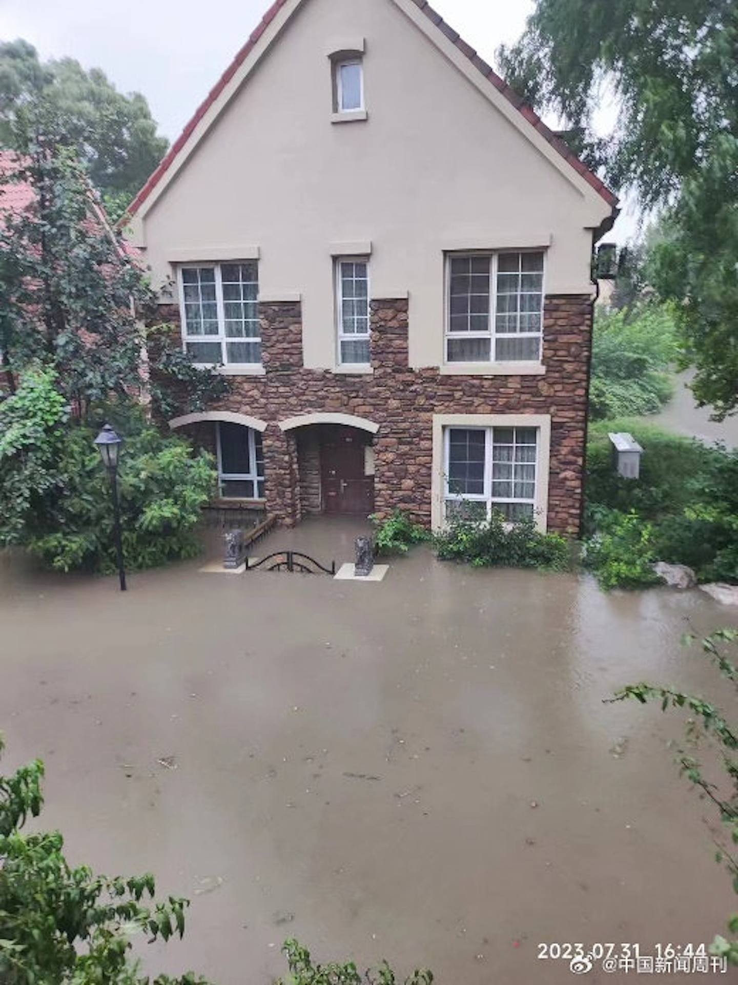 沿河屋苑过百人受困，洪水已漫过一楼。 （微博＠中国新闻周刊）