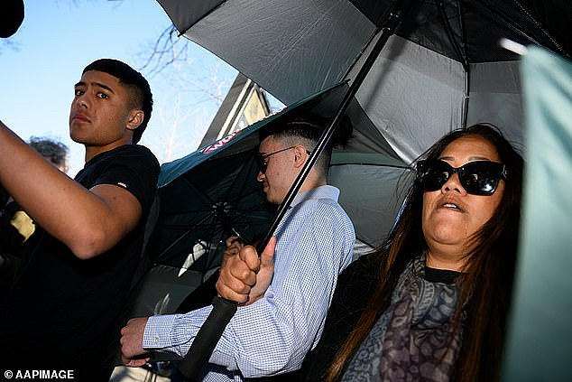 Edwards' family and friends held up umbrellas in an effort to conceal the teenager's face
