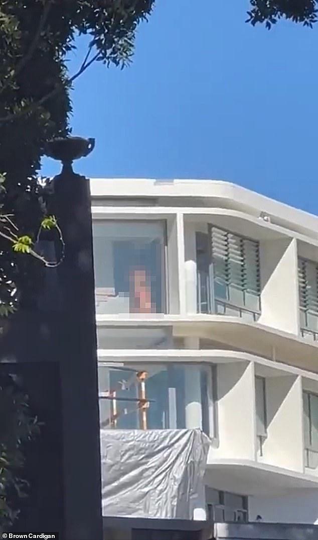 The shocking video appears to show a couple, who are completely naked, performing a sex act too graphic too describe in print in front full-length glass window filled with late winter sunshine (a still from the video is pictured)
