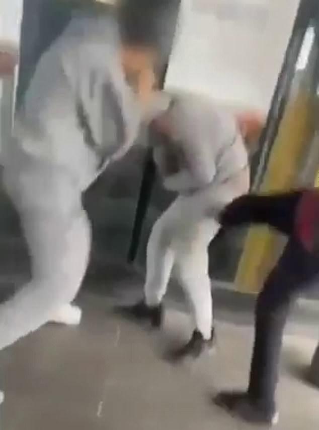 A group of four young thugs used a machete to threaten a teenager at St Albans station in west Melbourne on Tuesday (pictured, the group beating the victim, centre)