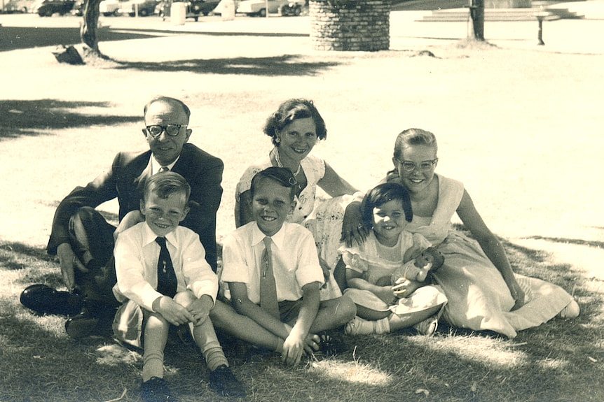 A black and white photo of a man, woman and four children
