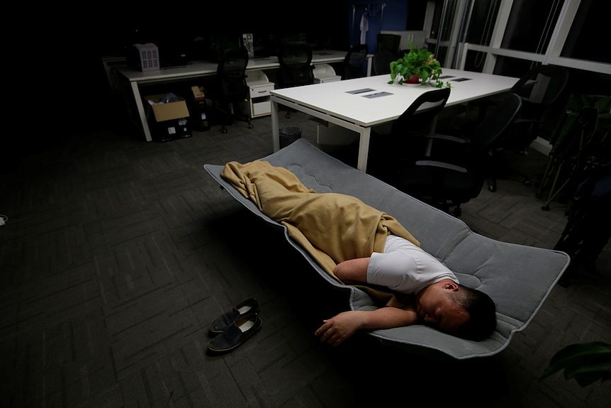 A man sleeping in bed in office