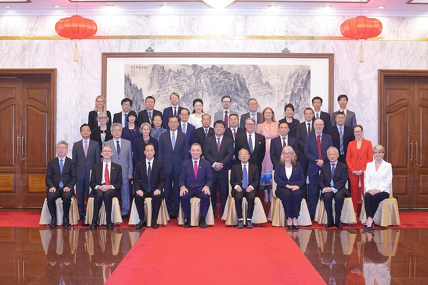 Australian and Chinese officials sitting in four rows for an official photo 