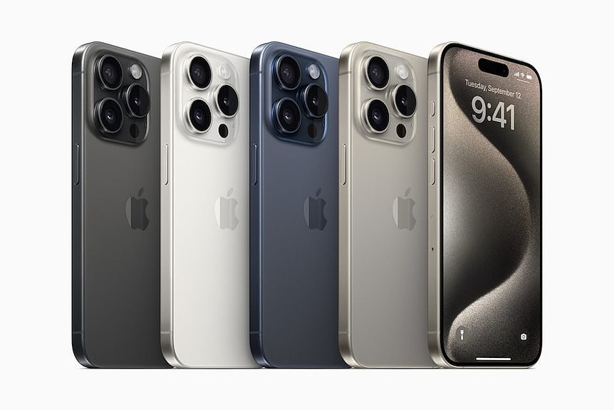 Five iPhone 15s in different colours against a plain white background