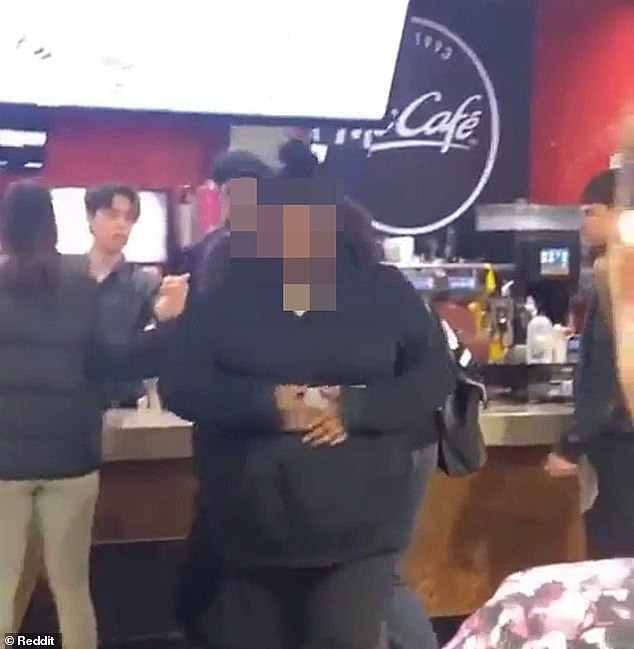 One of the four girls walks away from the counter as the scene turns into a full scale brawl