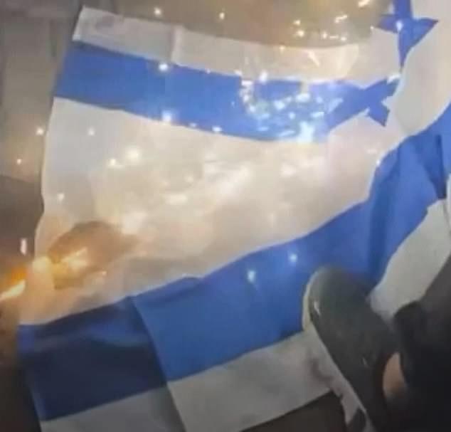 Daily Mail Australia witnessed a large crowd of men attempting to set light to an Israeli flag with firecrackers before resorting to stamping on it and tearing it into shreds (pictured)
