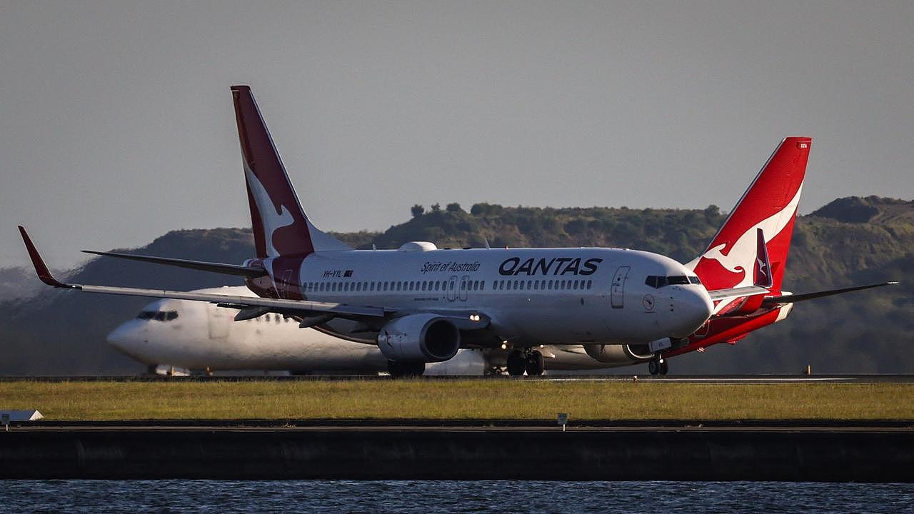 A Qantas Boeing 737-800 plane travels down the runway as another Qantas plane waits on the tarmac at Sydney’s Kingsford Smith international airport. Picture: AFP
