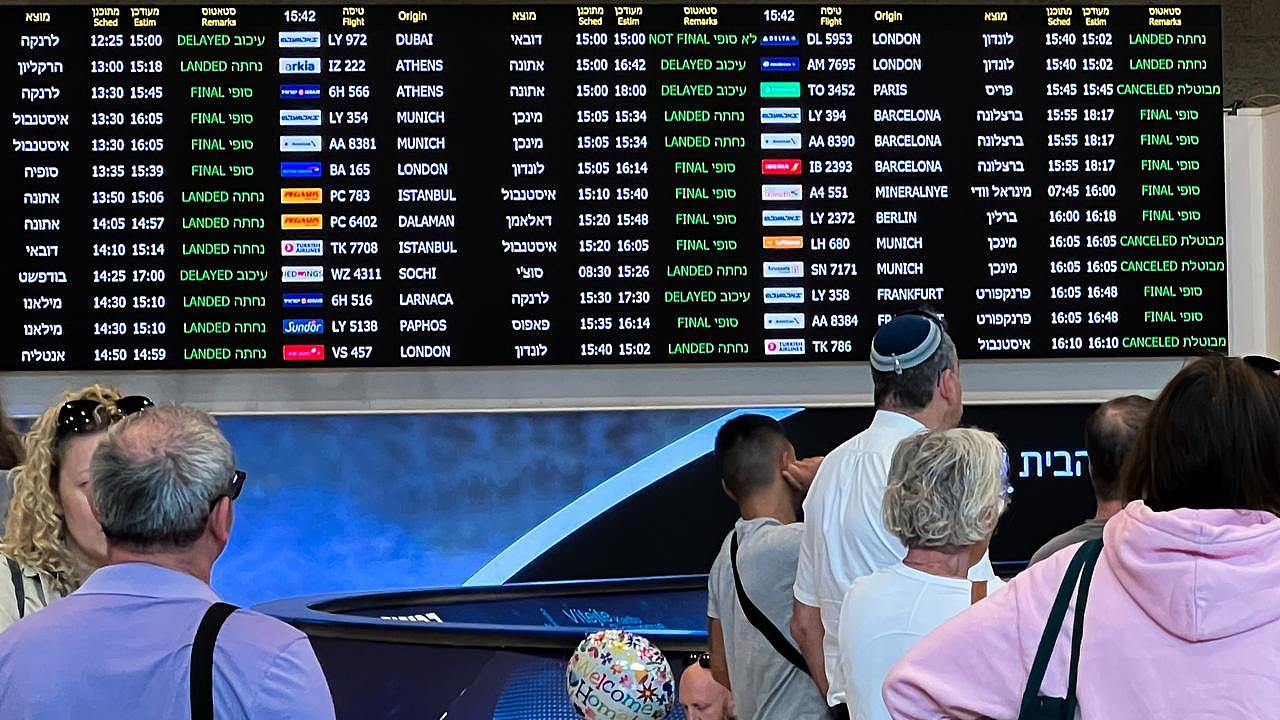 People wait for passengers arriving in near a sign showing landed and cancelled flights at the arrivals hall at Ben Gurion Airport in Lod, Israel. Picture: Getty Images
