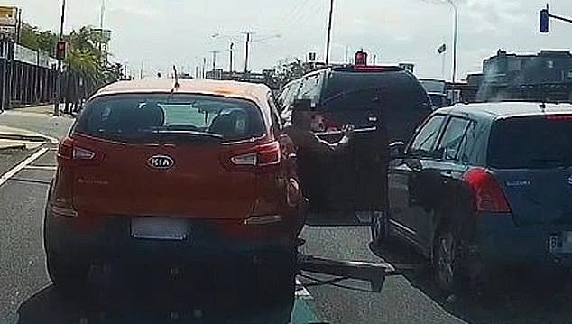 A shocking act of road rage at a busy intersection in Bundaberg was captured on dashcam footage as the shirtless driver (pictured centre) proceeds to lash out at the driver of the grey Suzuki hatchback for not giving him space in the right lane