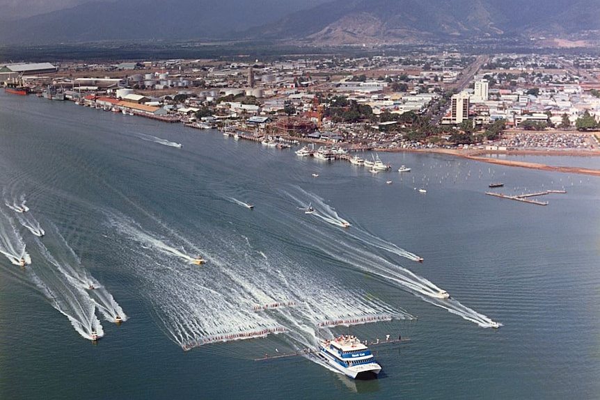 Aerial photo of 100 water skiers behind towed behind a catamaran in the Port of Cairns