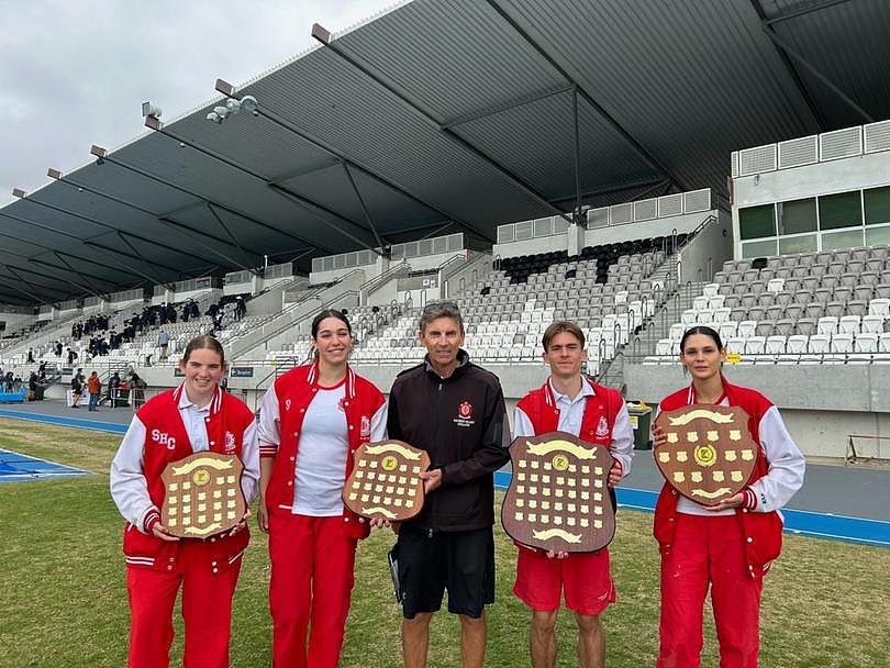 Sacred Heart College Year 12 students Jayde O’Donohoe, Isabella Rao, teacher Paul Clement, Alexander Day and Kylah Garlett holding the four ACC ‘A’ Division Athletics Carnival shields won by the school (Combined Aggregate, Junior Girls, Senior Boys and Overall Female). The college has won the Combined Aggregate of this athletics carnival for a record 25 consecutive years.