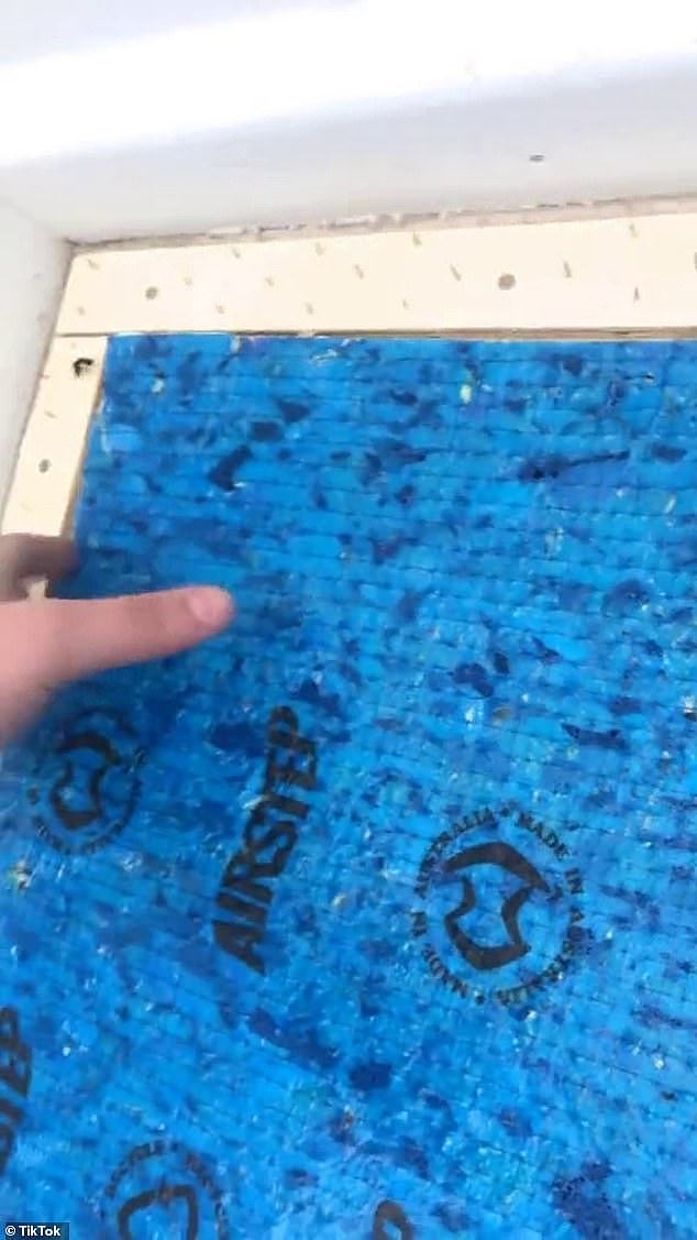 The hole had been covered up with a blue tarp like covering (pictured) and a carpet and was among several issues that were found inside the property