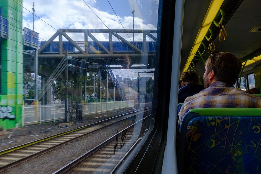 一名乘客从火车窗子看向外面。