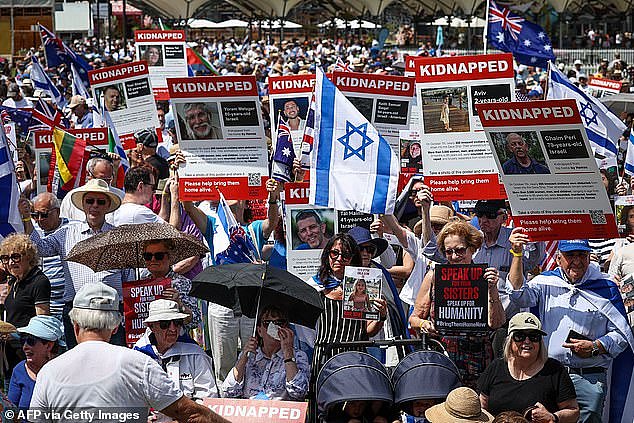 Members of the Australian Jewish community and supporters hold placards and flags during a rally in Sydney on November 12, 2023
