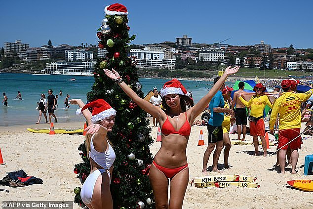 Calls to reintroduce mask mandates before Christmas because of the recent increase in the number of Covid-19 cases have been rejected by leading medical experts (pictured, beach-goers celebrate Christmas Day on Bondi Beach)